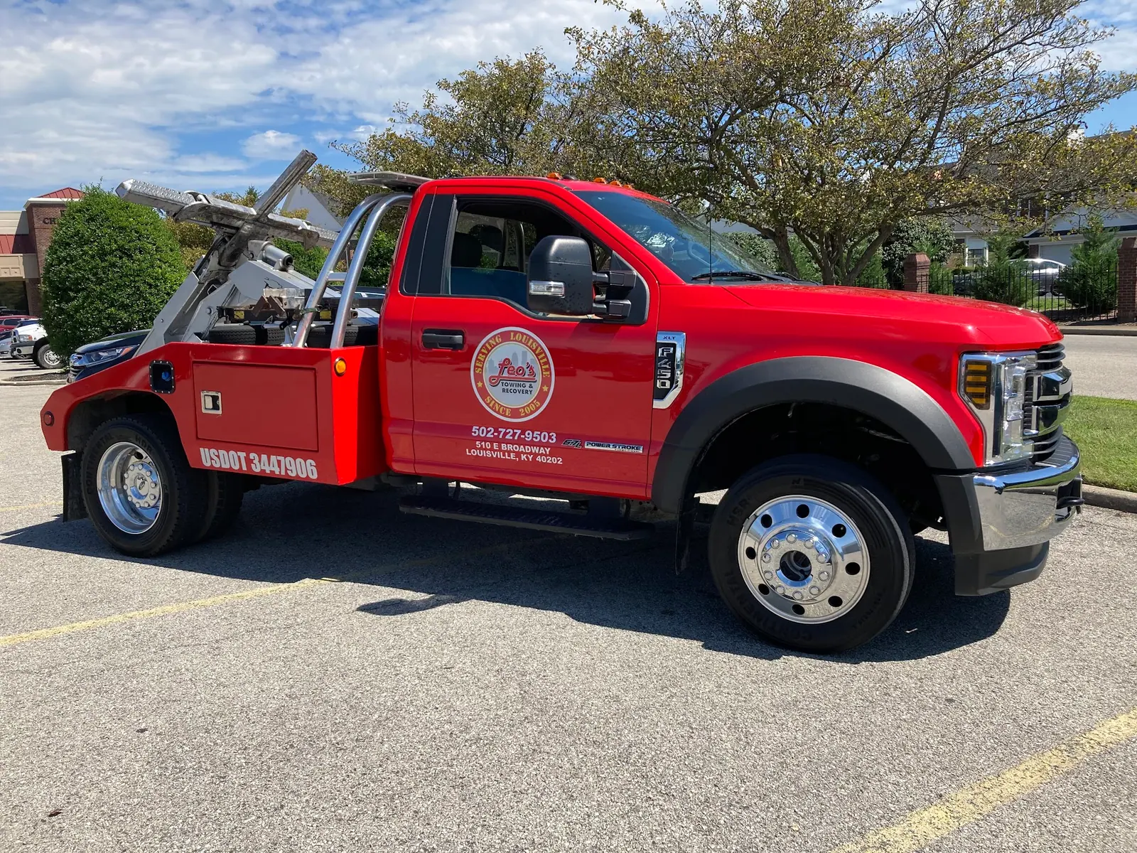 Leo's red wrecker truck parked side-on in a Louisville lot